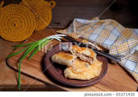 Clay plate of fried meat pies with cutlery and 65371430