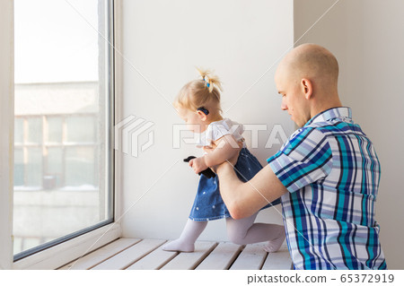 Baby girl wearing a hearing aid. Disabled child, disability and deafness concept. Baby girl wearing a hearing aid. Disabled child, disability and deafness concept. 65372919