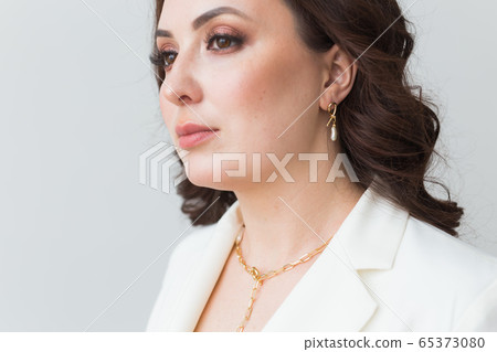 Close-up of woman wearing a gold necklace. Jewelry, bijouterie and accessories concept. Close-up of woman wearing a gold necklace. Jewelry, bijouterie and accessories concept. 65373080