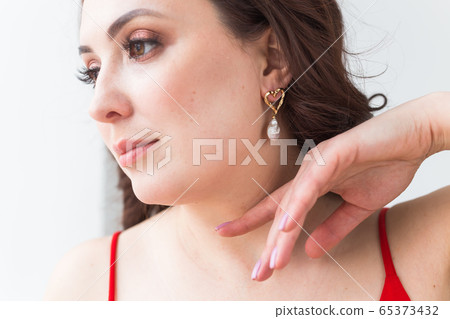 Close-up portrait of beautiful young woman with elegant hairstyle and luxurious jewelry and bijouterie. 65373432