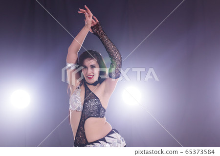 Spirituality dance. Beautiful sexy woman with luxury glossy eastern make-up dancing tribal fusion. Belly dance. Copy space. 65373584