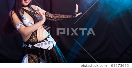 Belly dancer. Young attractive woman dancing tribal fusion on the stage. Oriental exotic dance. Belly dancer. Young attractive woman dancing tribal fusion on the stage. Oriental exotic dance. 65373653