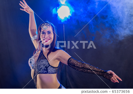 Young woman dancing in Tribal Fusion style. Belly dance on the stage. Young woman dancing in Tribal Fusion style. Belly dance on the stage. 65373656