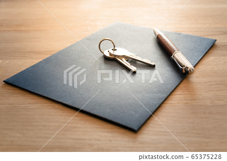 Keys, pen and envelope on the wooden table. Selling or rental of flat, house or another real estate or object. Symbol of agreement Keys, pen and envelope on the wooden table. Selling or rental of flat, house or another real estate or object. Symbol of agreement 65375228