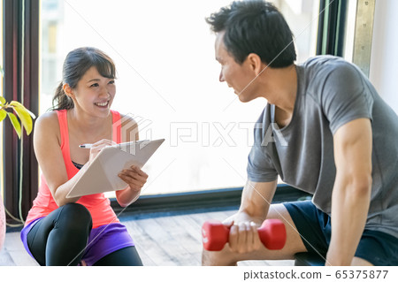 Personal gym female trainer instructor dumbbell 65375877
