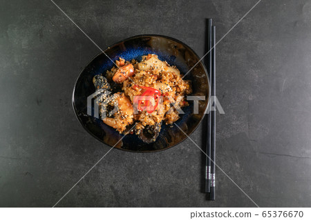 beef tahan fried Japanese rice with vegetables and slices of beef in a black plate beef tahan fried Japanese rice with vegetables and slices of beef in a black plate 65376670