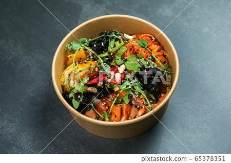Hawaiian salmon fish poke bowl with rice, radish,cucumber, tomato, sesame seeds and seaweeds. Buddha bowl. Diet food 65378351