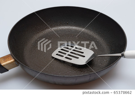 Old and oiled frying pan and flipper 65378662