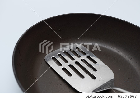 Old and oiled frying pan and flipper 65378668