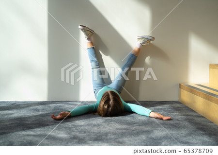 Adorable kid lying on the floor and raising legs 65378709