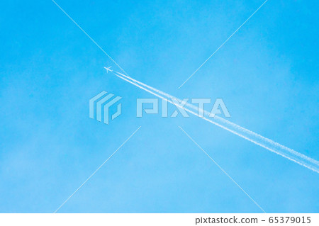 Airplane flying in the clear blue sky with white trail along the route. Jet with contrail in high speed 65379015