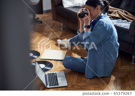Caucasian cute woman using camera at home 65379267