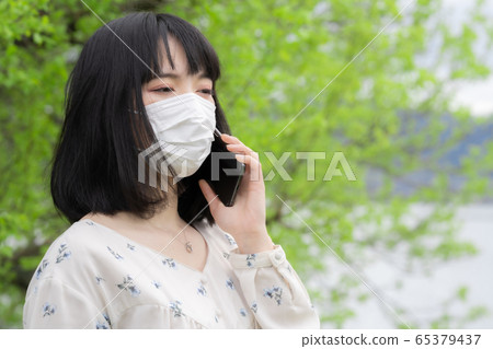 戴著面具談智能手機的女人 65379437