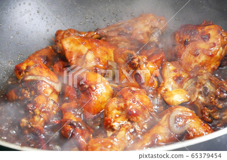 Fried chicken cooked with black soy sauce. The chicken pieces are fried over dry and then poured with soy sauce and onion. Fried chicken cooked with black soy sauce. The chicken pieces are fried over dry and then poured with soy sauce and onion. 65379454