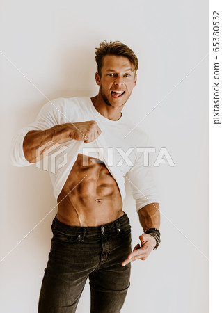 Muscular man on a diet showing abs muscles 65380532