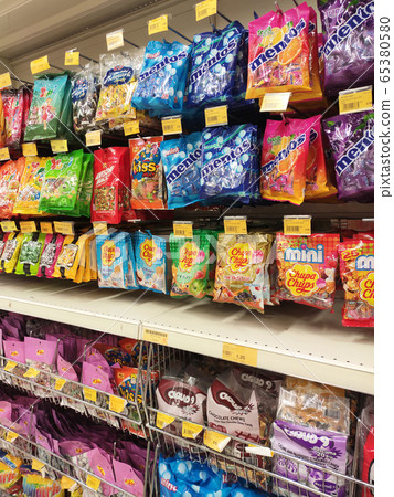 The candies are wrapped in commercial plastic packaging and labelled by brand. Display on a supermarket shelf for sale. Every item has a different price tag. The candies are wrapped in commercial plastic packaging and labelled by brand. Display on a supermarket shelf for sale. Every item has a different price tag. 65380580