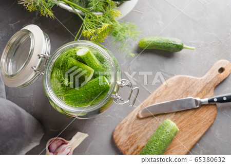 Pickling cucumbers in glass jar with mineral water 65380632