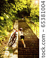 9 years girl bring up for the stairs her bicycle in the sunny day 65381004