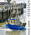 A small fishing boat enters the harbour of Busum in North Frisia in Germany. 65381824