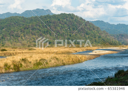scenic landscape of Ramganga River with mountains and clouds in sky at dhikala zone of corbett national park or tiger reserve, uttarakhand, india 65381946