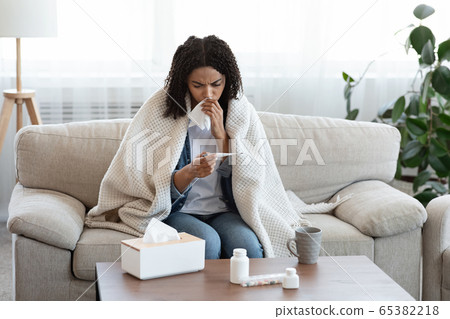Flu Symptoms. Ill African Woman Checking Her Body Temperature At Home 65382218