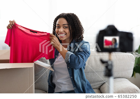 Unboxing Video. Young Black Woman Fashion Blogger Recording Content At Home Unboxing Video. Young Black Woman Fashion Blogger Recording Content At Home 65382250