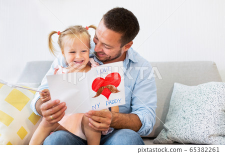 Little daughter congratulating dad with father's day Little daughter congratulating dad with father's day 65382261