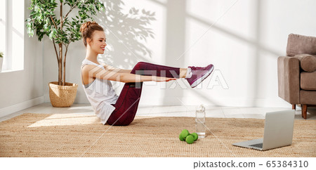 Happy woman doing sports exercise at home. 65384310