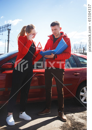 Driving instructor and woman student in examination car. 65384337