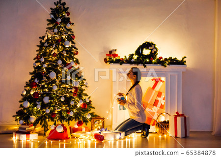beautiful woman decorates the Christmas tree Garland lights new year holiday beautiful woman decorates the Christmas tree Garland lights new year holiday 65384878