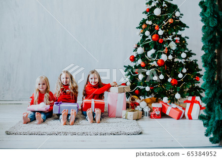 Christmas holiday three girl with gifts the new year tree decoration on a grey background gifts 65384952