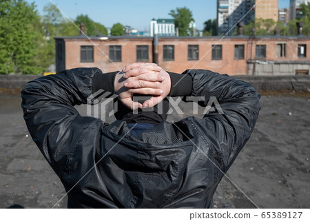 the hands of the detained bandit are closed behind the head the hands of the detained bandit are closed behind the head 65389127