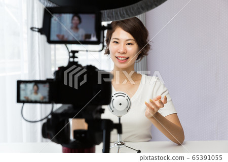 一個女人用單反相機拍攝視頻 65391055