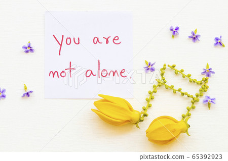 you are not alone message card handwriting with  yellow flowers ylang ylang arrangement music score 65392923