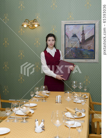 Young beautiful waitress serving the table in the restaurant Young beautiful waitress serving the table in the restaurant 65393036
