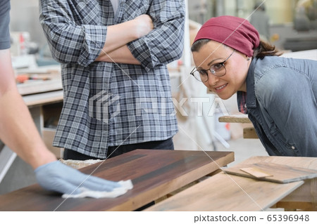 Woodworking workshop, worker varnishing wooden shelf closeup Woodworking workshop, worker varnishing wooden shelf closeup 65396948