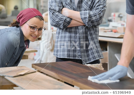 Woodworking workshop, worker varnishing wooden shelf closeup Woodworking workshop, worker varnishing wooden shelf closeup 65396949