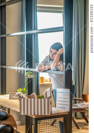 Young woman standing near the table and looking stressed 65399193