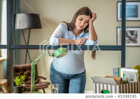 Young woman standing in the room and looking desperate Young woman standing in the room and looking desperate 65399195