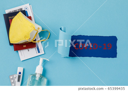 Coronavirus and travel concept. Passports, airplane tickets, sanitizer, thermometer and medical mask flat lay Coronavirus and travel concept. Passports, airplane tickets, sanitizer, thermometer and medical mask flat lay 65399435