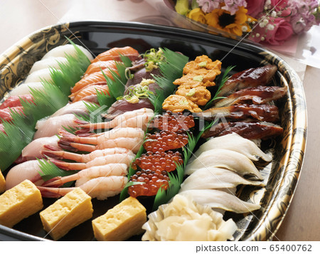 取出鮮魚壽司拼盤參加家庭聚會並吃得熱鬧的場景 取出鮮魚壽司拼盤參加家庭聚會並吃得熱鬧的場景 65400762