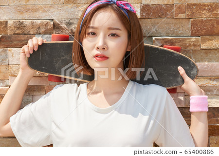Pretty teenage woman riding a skateboard Pretty teenage woman riding a skateboard 65400886