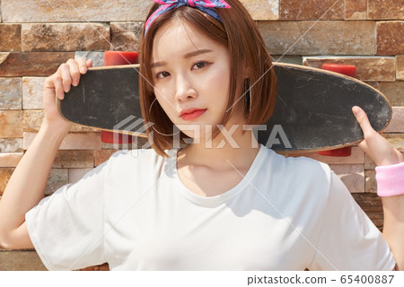 Pretty teenage woman riding a skateboard Pretty teenage woman riding a skateboard 65400887