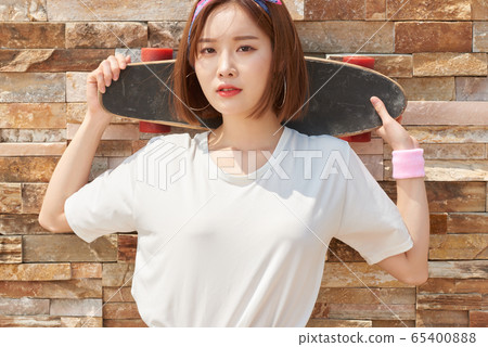 Pretty teenage woman riding a skateboard Pretty teenage woman riding a skateboard 65400888