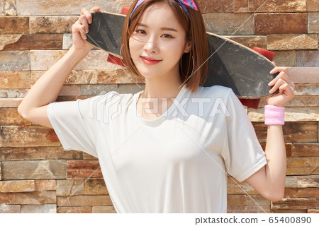 Pretty teenage woman riding a skateboard Pretty teenage woman riding a skateboard 65400890