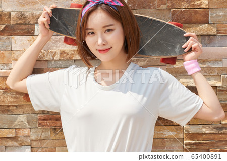 Pretty teenage woman riding a skateboard Pretty teenage woman riding a skateboard 65400891