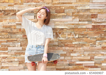 Pretty teenage woman riding a skateboard Pretty teenage woman riding a skateboard 65400907