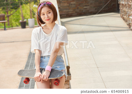 Pretty teenage woman riding a skateboard Pretty teenage woman riding a skateboard 65400915