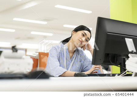 Thinking woman while looking at the computer screen Thinking woman while looking at the computer screen 65401444