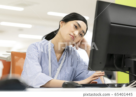 Thinking woman while looking at the computer screen Thinking woman while looking at the computer screen 65401445